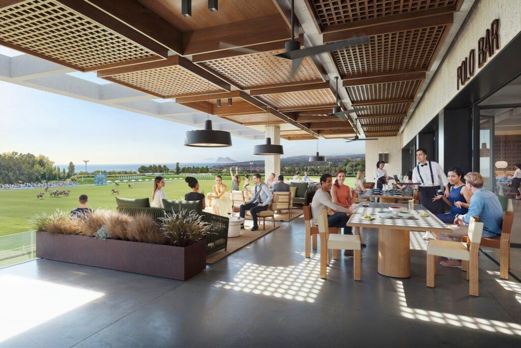 Elegant terrace bar overlooking a polo match in Sotogrande, with guests dining and socializing in a refined, open-air setting.