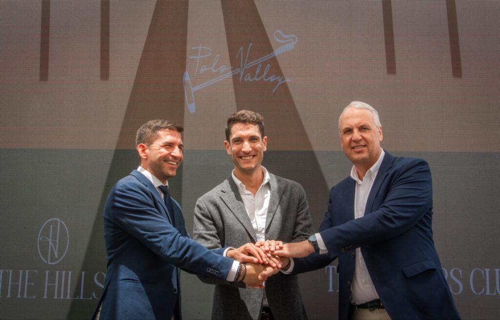 Three men smiling and shaking hands on stage at a Sotogrande investment event, symbolizing partnership between Polo Valley, The Hills, and local authorities.